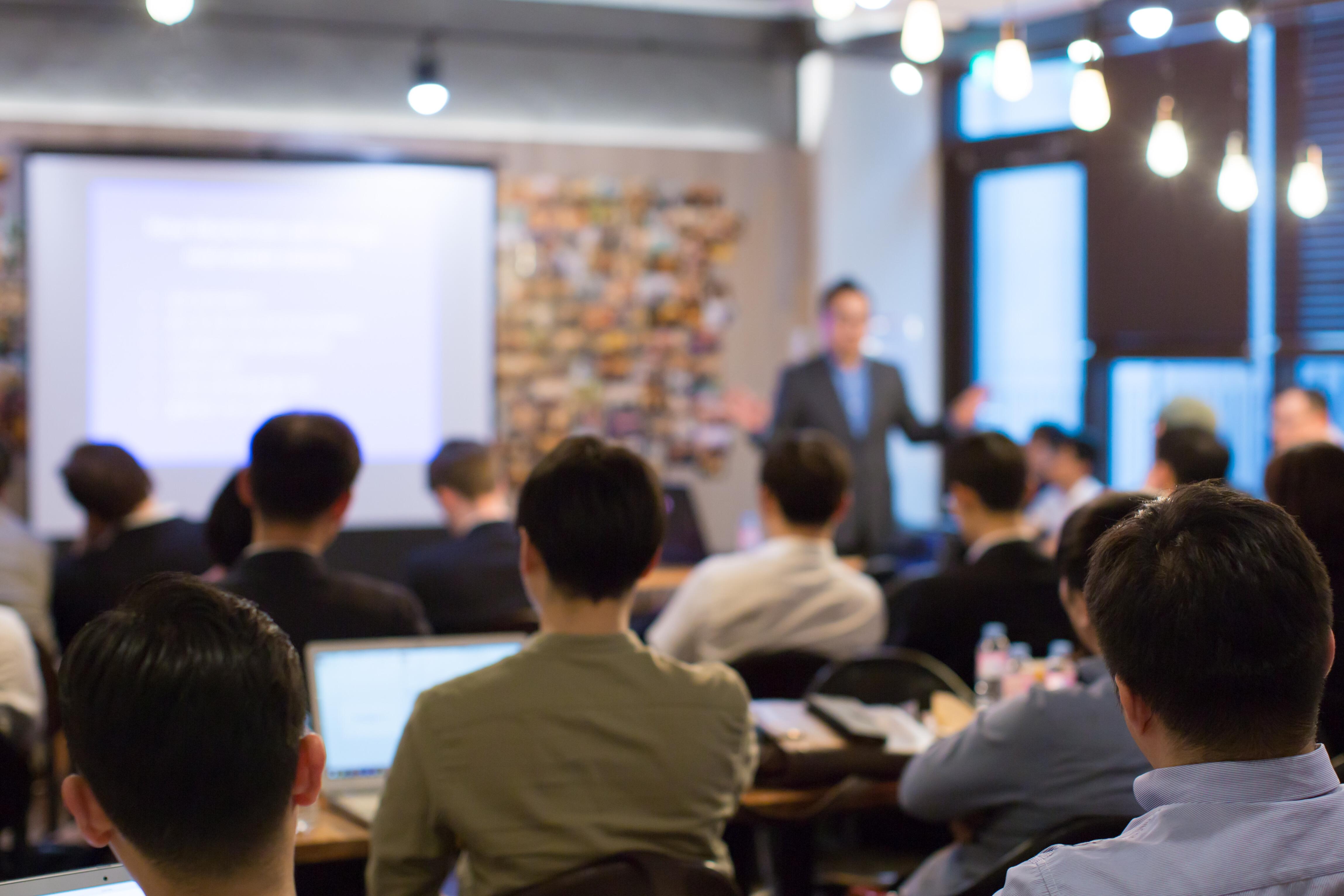 Business People Meeting and Working while Business Executive Lead Presenter Speaks to Group