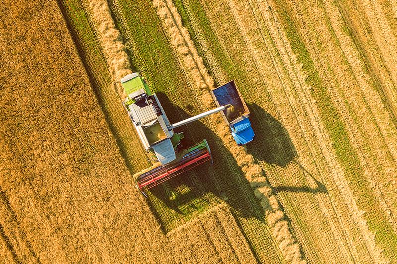 Aerial shots of tractors working on an agriculture field