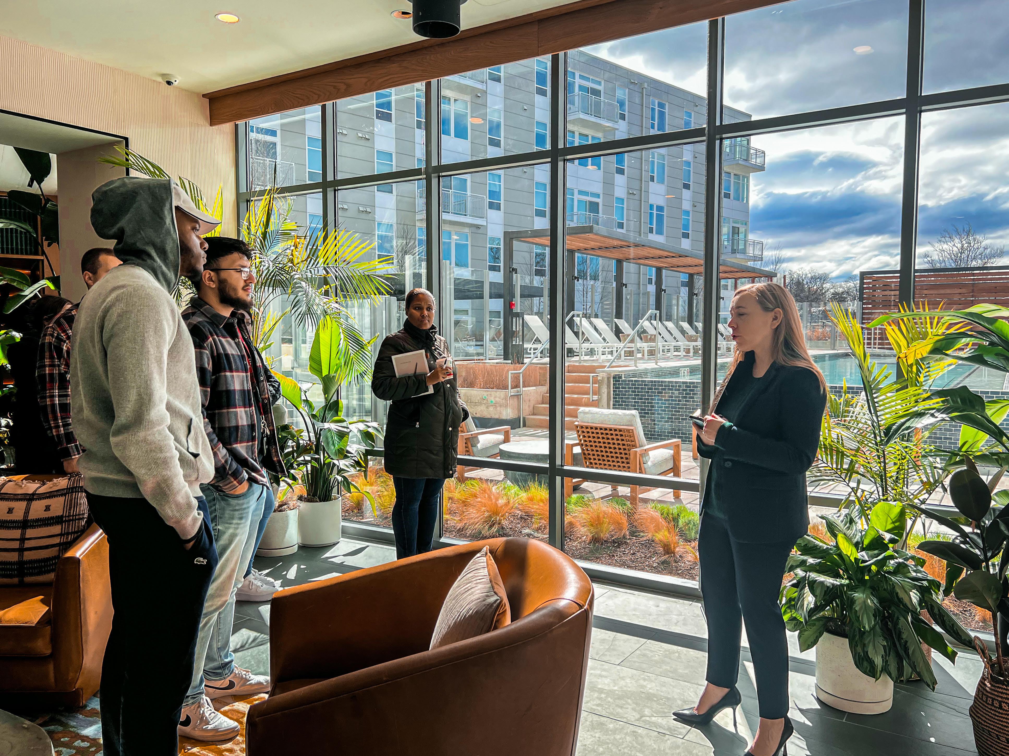 Students inside a building with large windows and plants