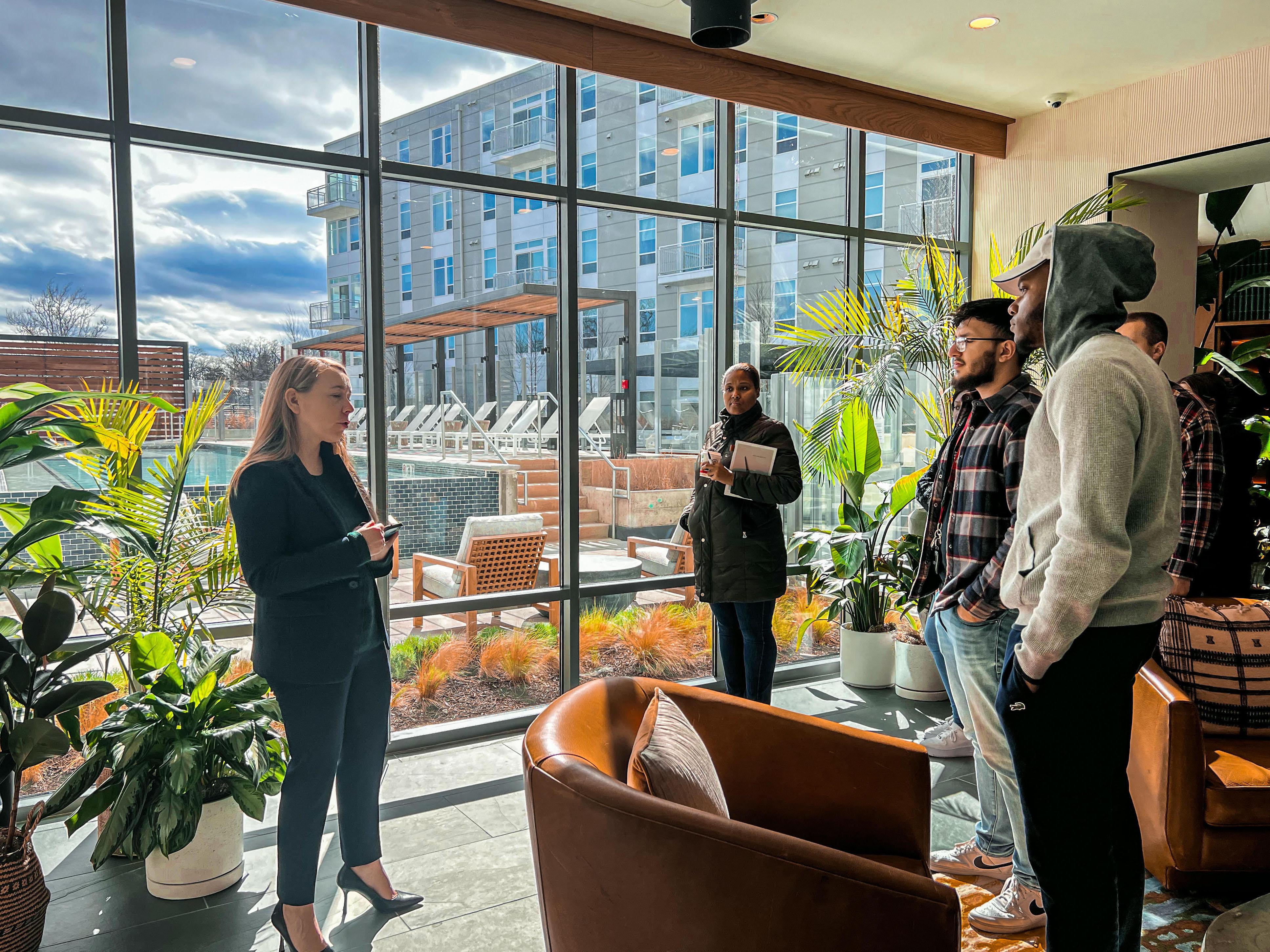 Students inside a building with large windows and plants
