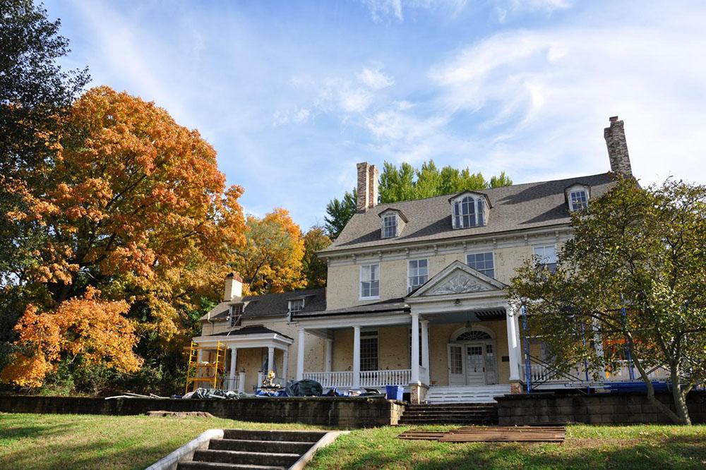 Bostwick House with fall trees and a bright blue sky