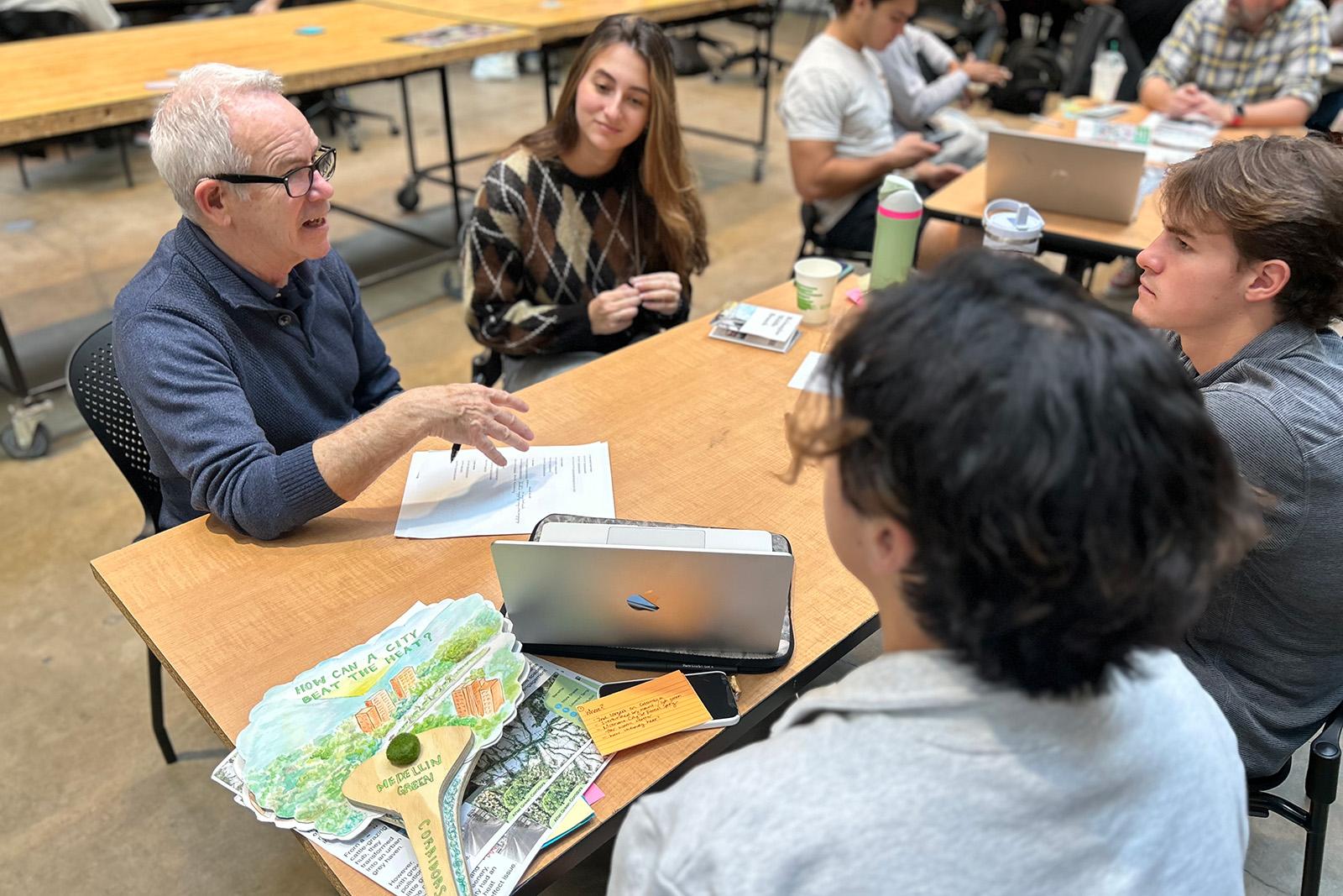 Professor talking to students around a table