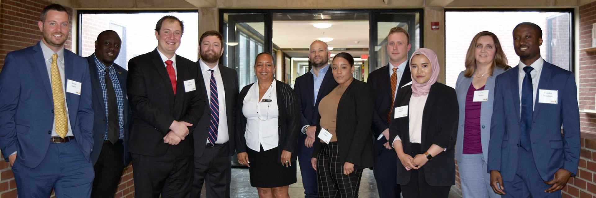 A group shot of students and faculty dressed in business attire.