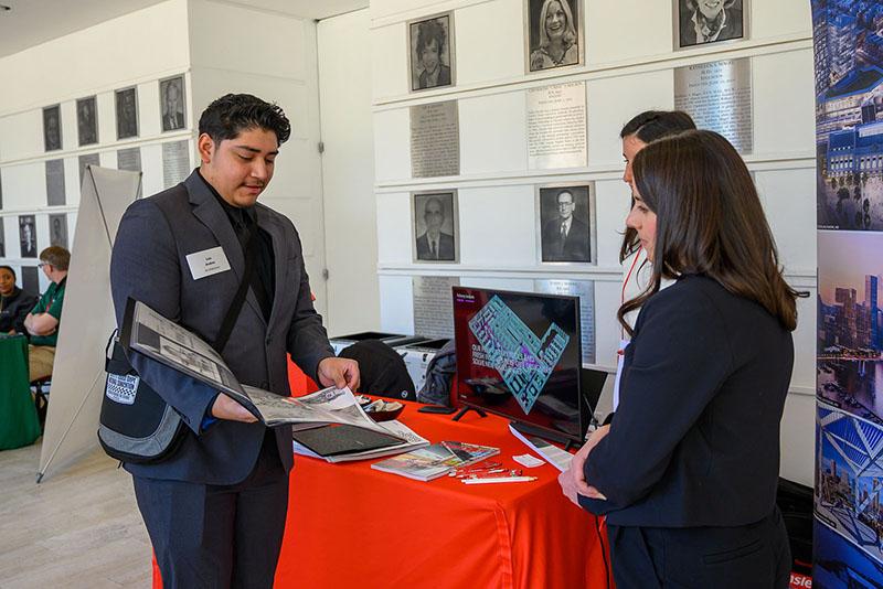 Student showing their portfolio at a career fair