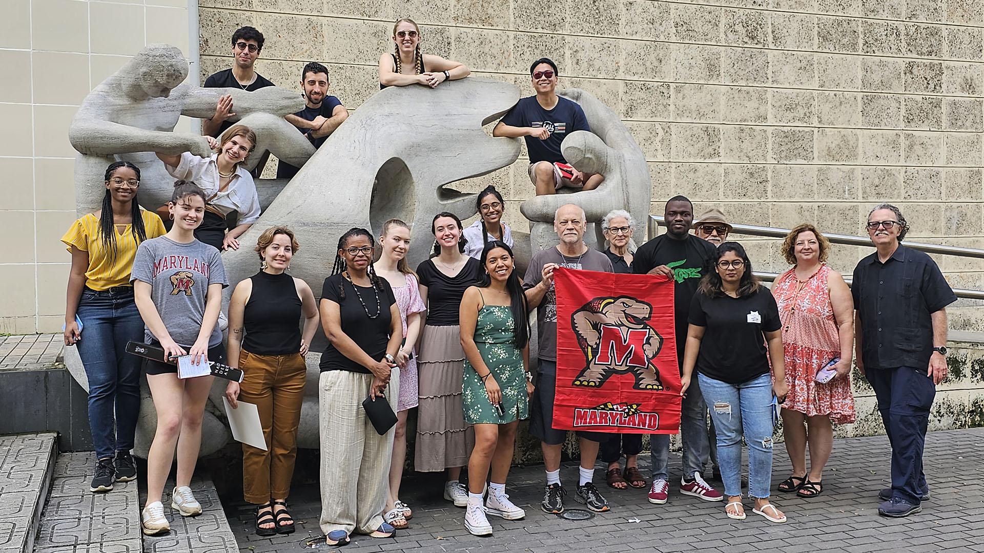 Students and faculty posing in Havana with a Maryland Terp flag