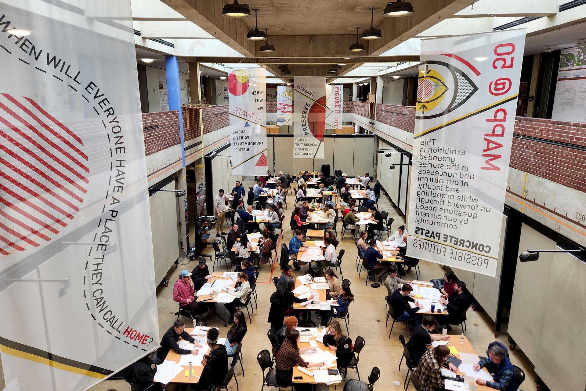 Many tables set up in the Great Space with banners hanging