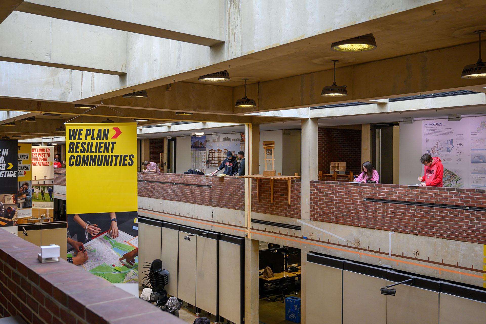 Students sketching in the Mezzanine, banners are hanging saying: We plan Resilient Communities
