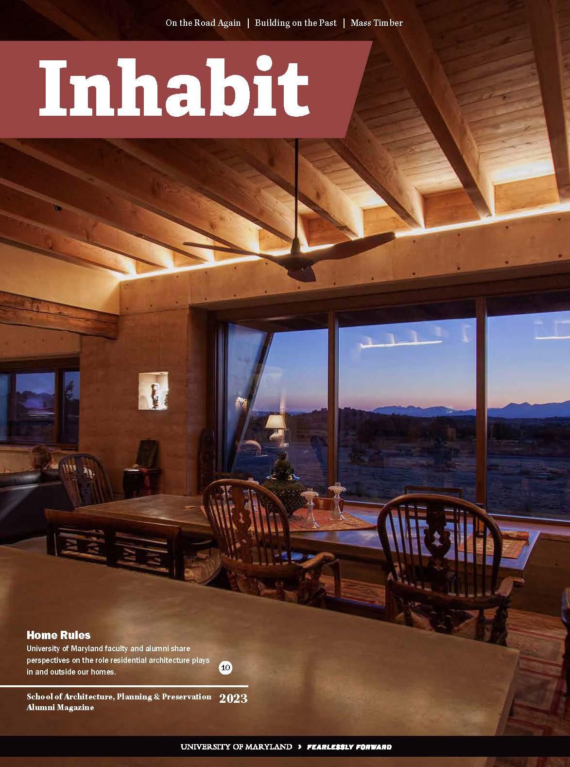 Inhabit Magazine cover showing the interior of a house's living room at dusk with lots of wood and warm tones