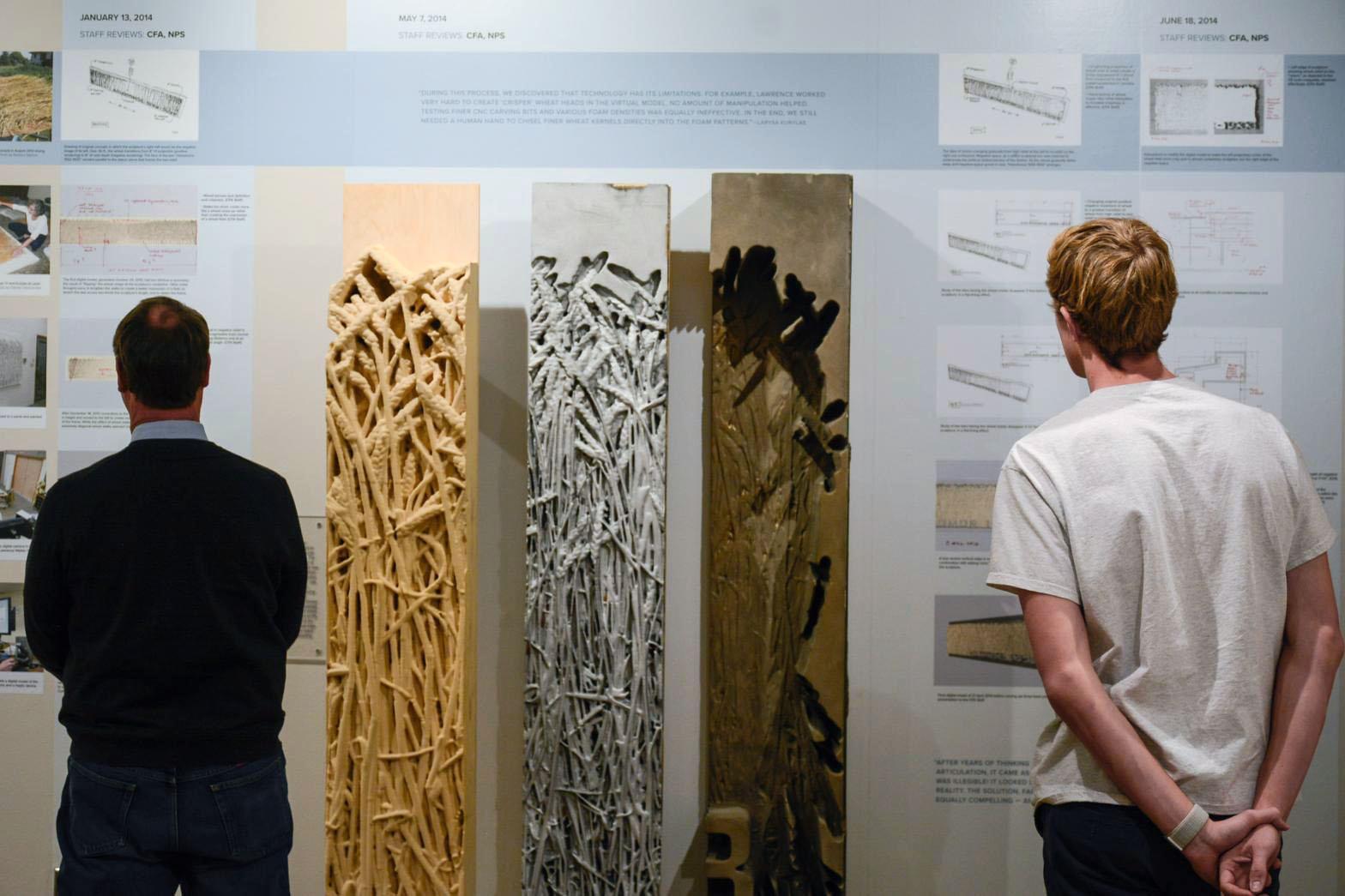 People looking at molds for the Holodomor Memorial at the Kibel Gallery exhibit