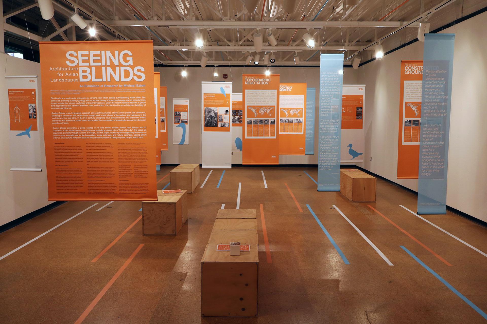 Seeing blinds exhibit with orange and blue banners