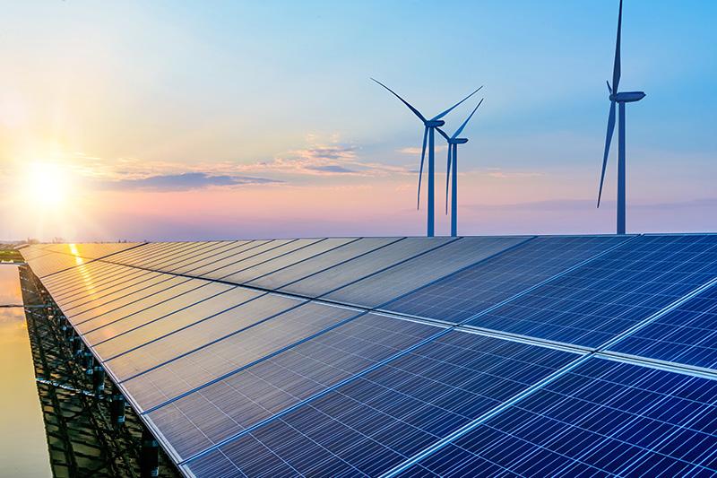 Solar panels and wind turbines with sunrise