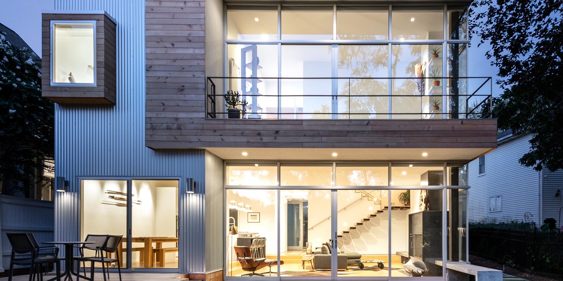 A grid-structured home with large windows, pictured at dusk.