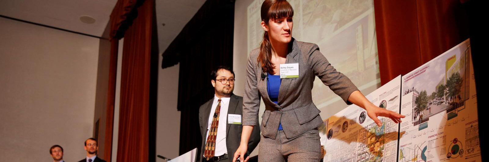 A woman pointing to a presentation board