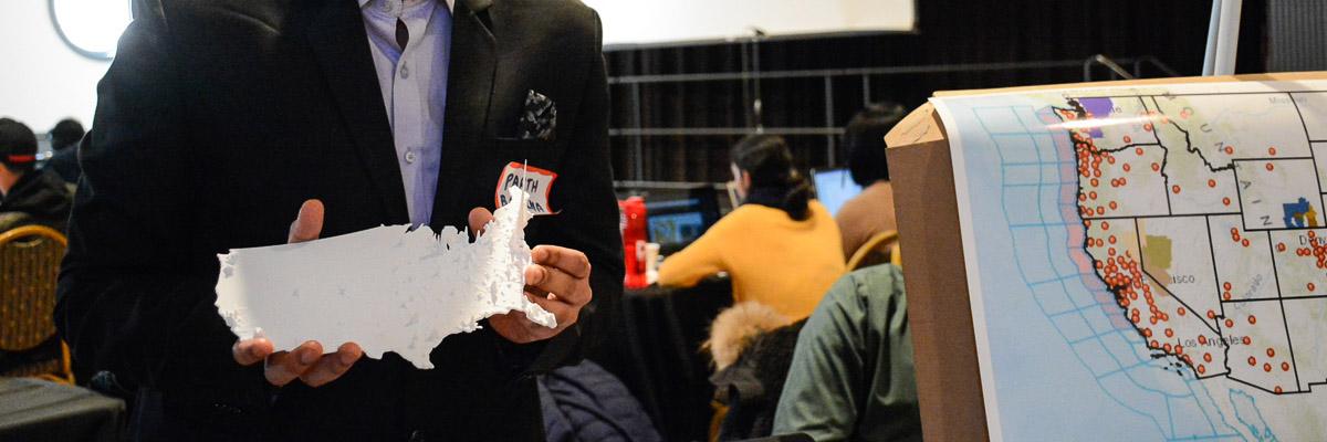 Data map on the right and student holding a 3D printed U.S. map with data showcased as elevations