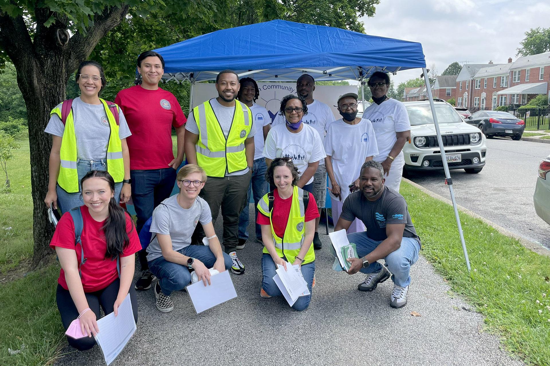 Group photo of the WET team and community wearing safety vests