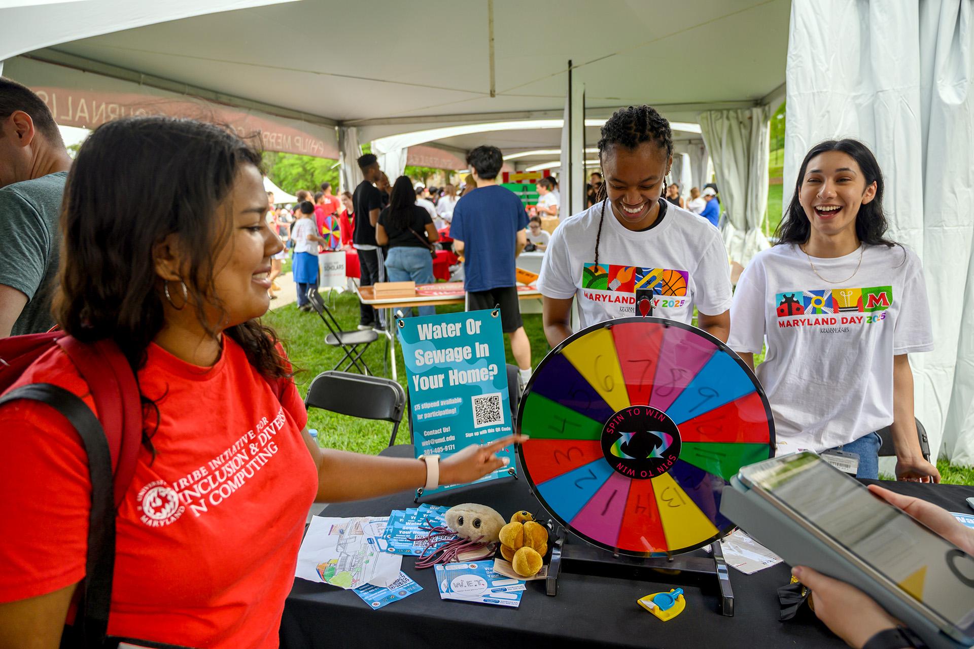 People laughing while one woman spins a wheel to learn about water and sewage.