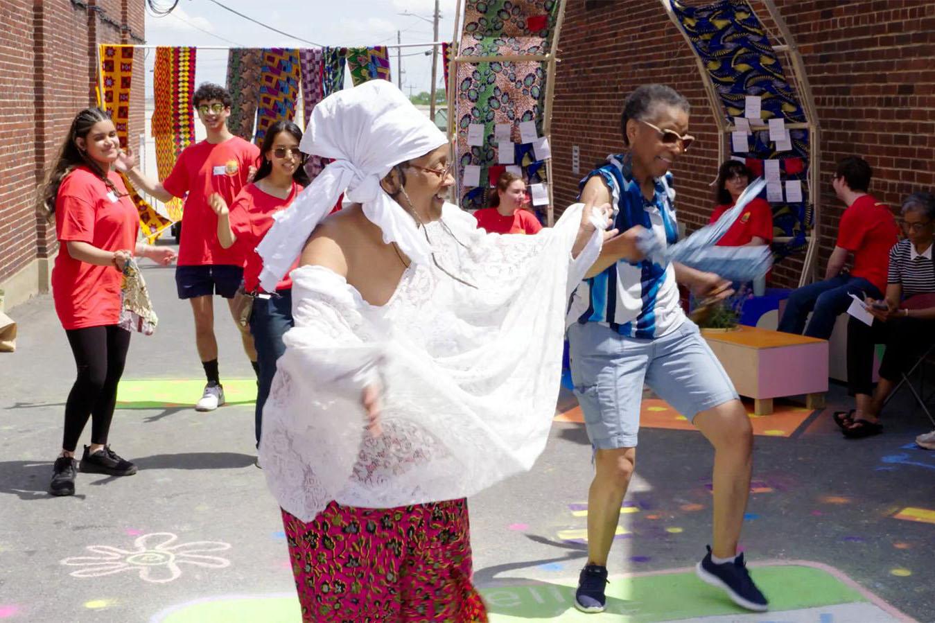 Woman leading a dance with people following her moves in the background
