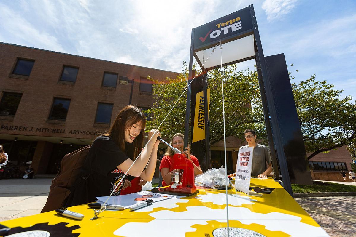 Student making a button at the Terps Vote booth