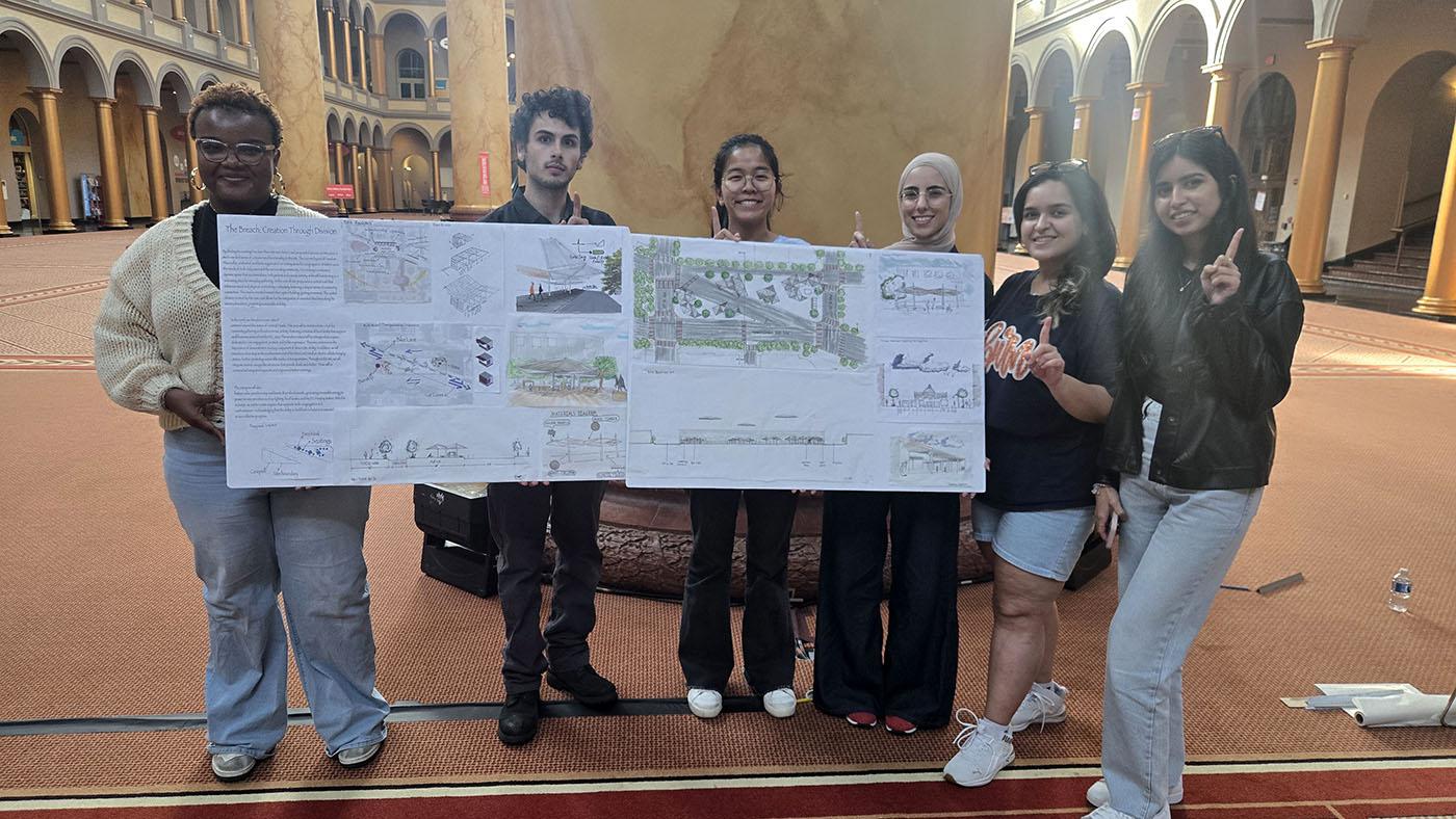 Students posing with their competition board in the National Building museum