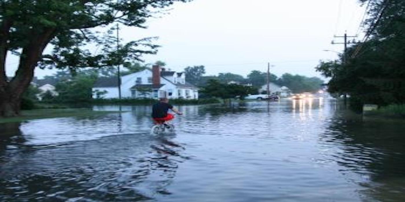 Individual biking through a flooded street