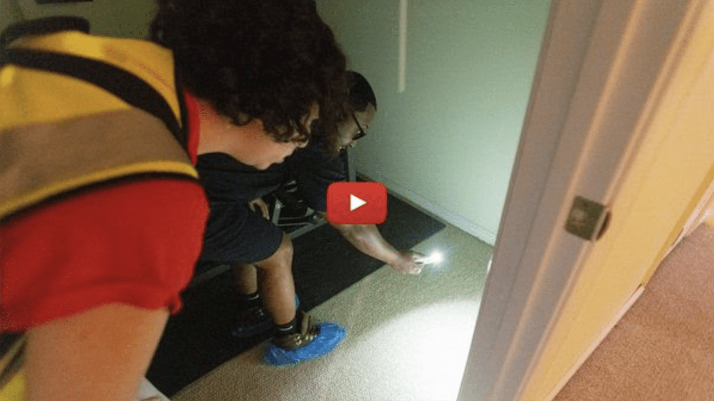 Screenshot of of two people inspecting water with a flashlight