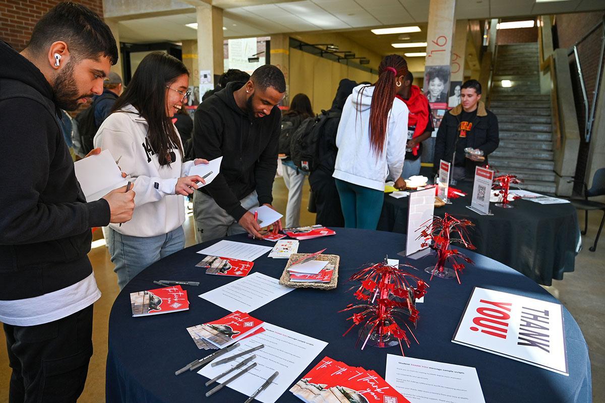 Students around a table signing thank you cards