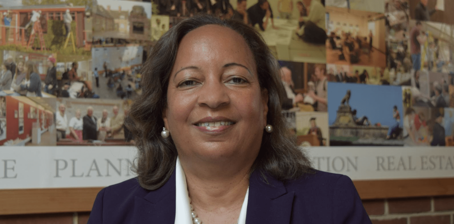 A lady in business attire smiling for a photo. 