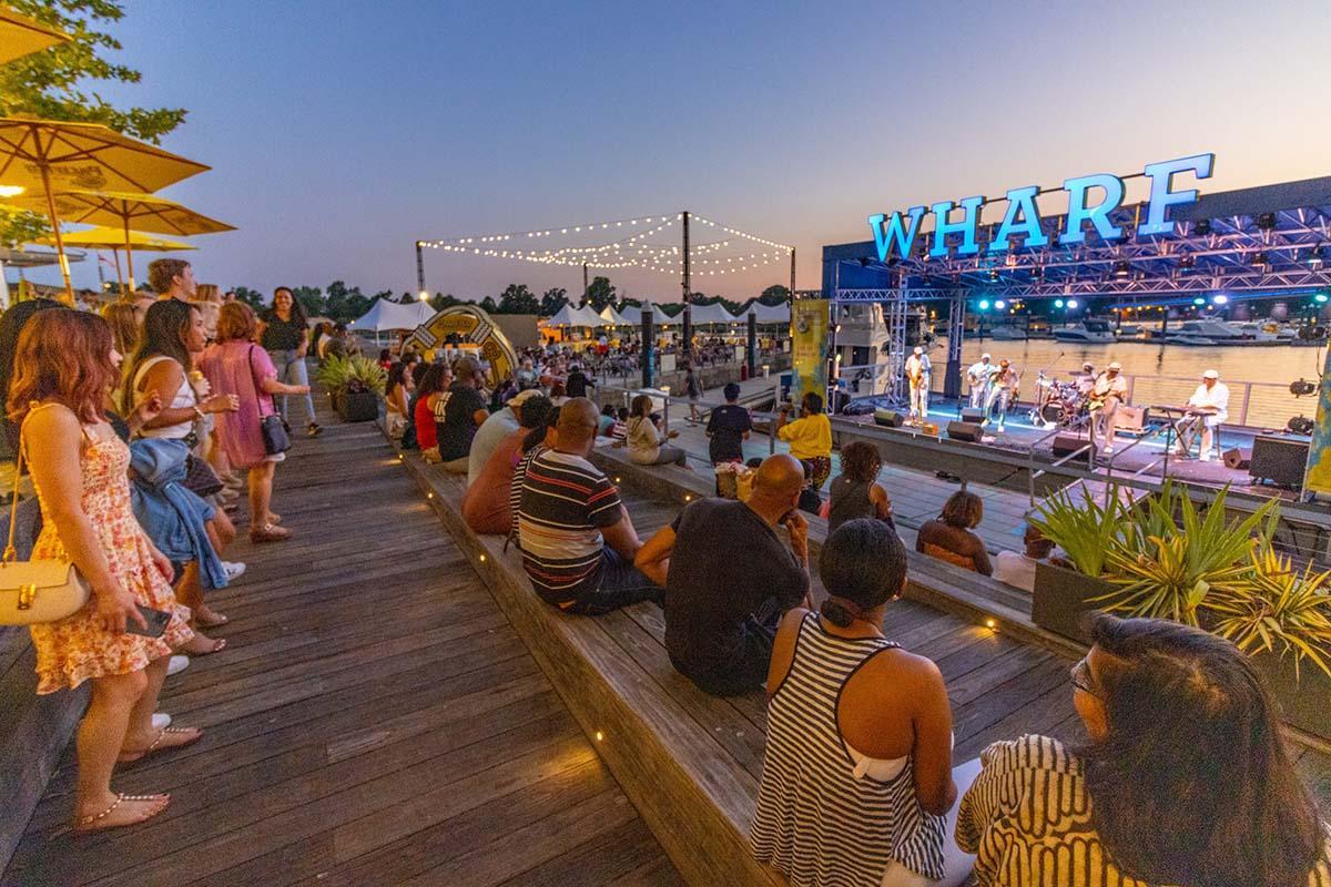 People sitting at the Wharf in Washington DC at dusk