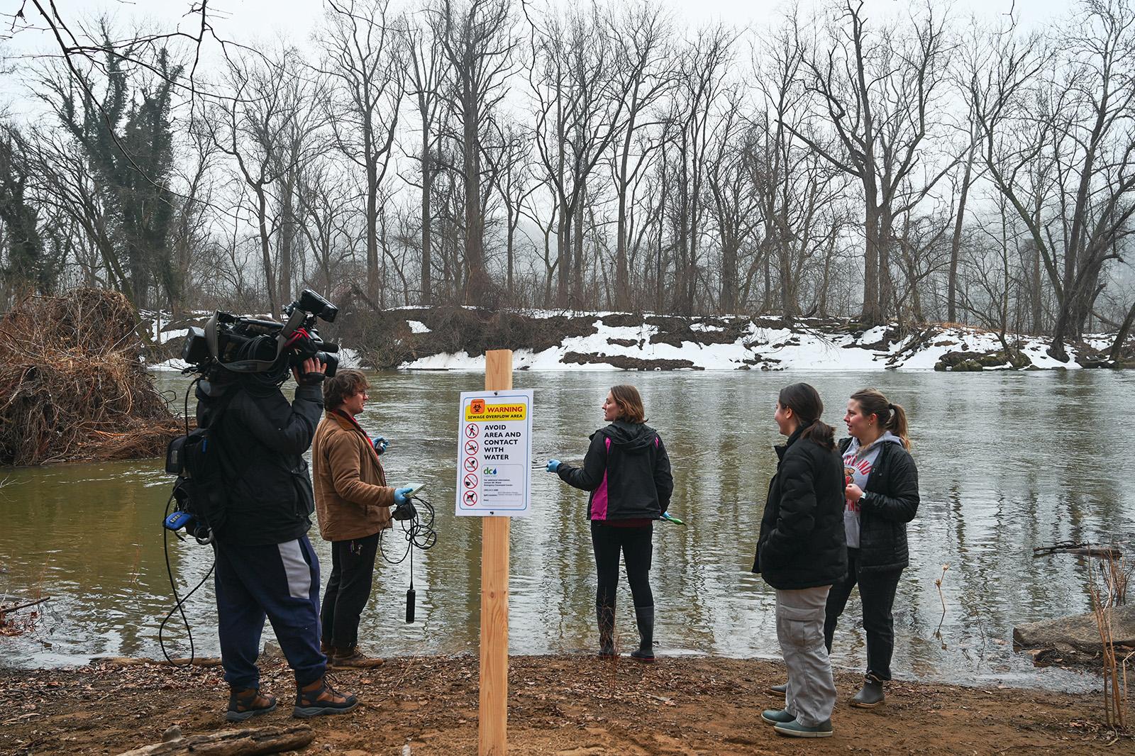 Crew members and people gathered by the Potomac River