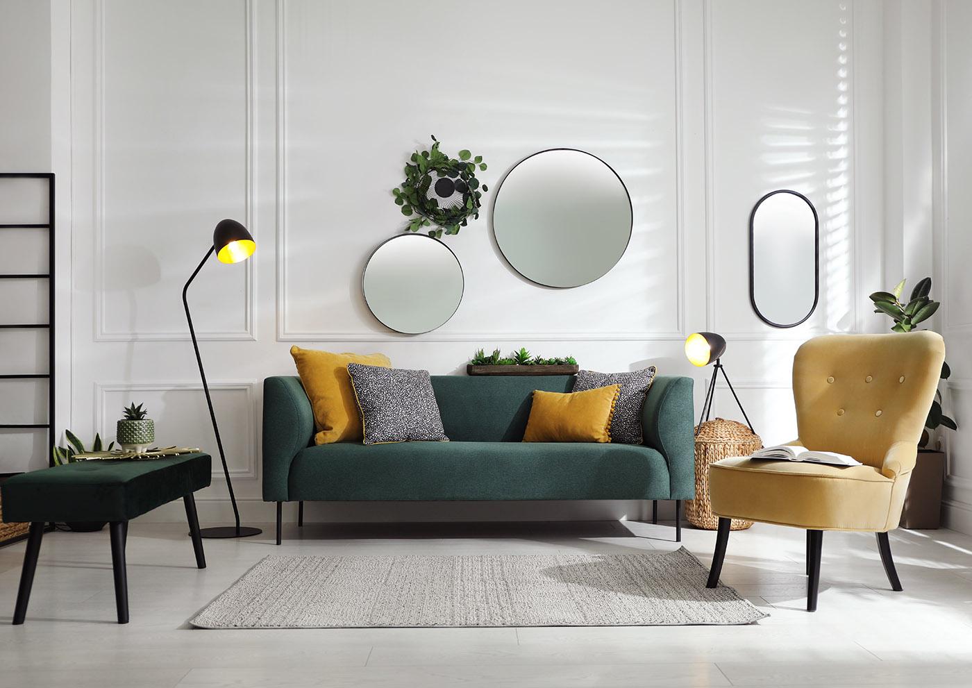 Interior design showing a living room set up with dark green and mustard yellow furniture accent colors. 
