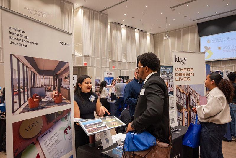 A career fair employee looking at a students portfolio