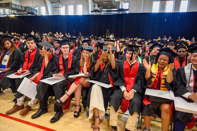 Students moving their tassels and clapping at commencement