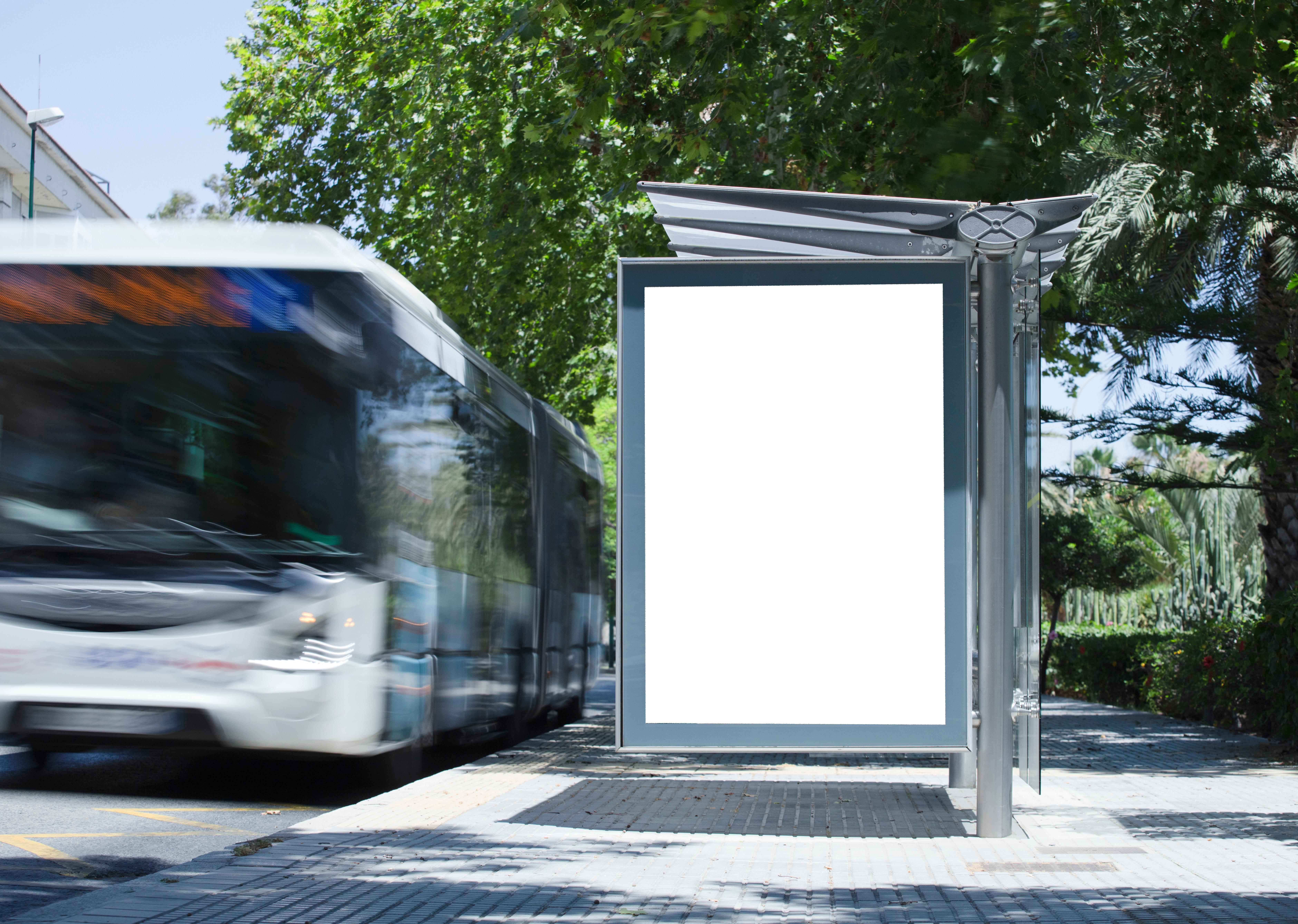 White blank vertical billboard at the bus stop on the city street