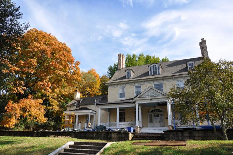 Bostwick House with fall trees and a bright blue sky